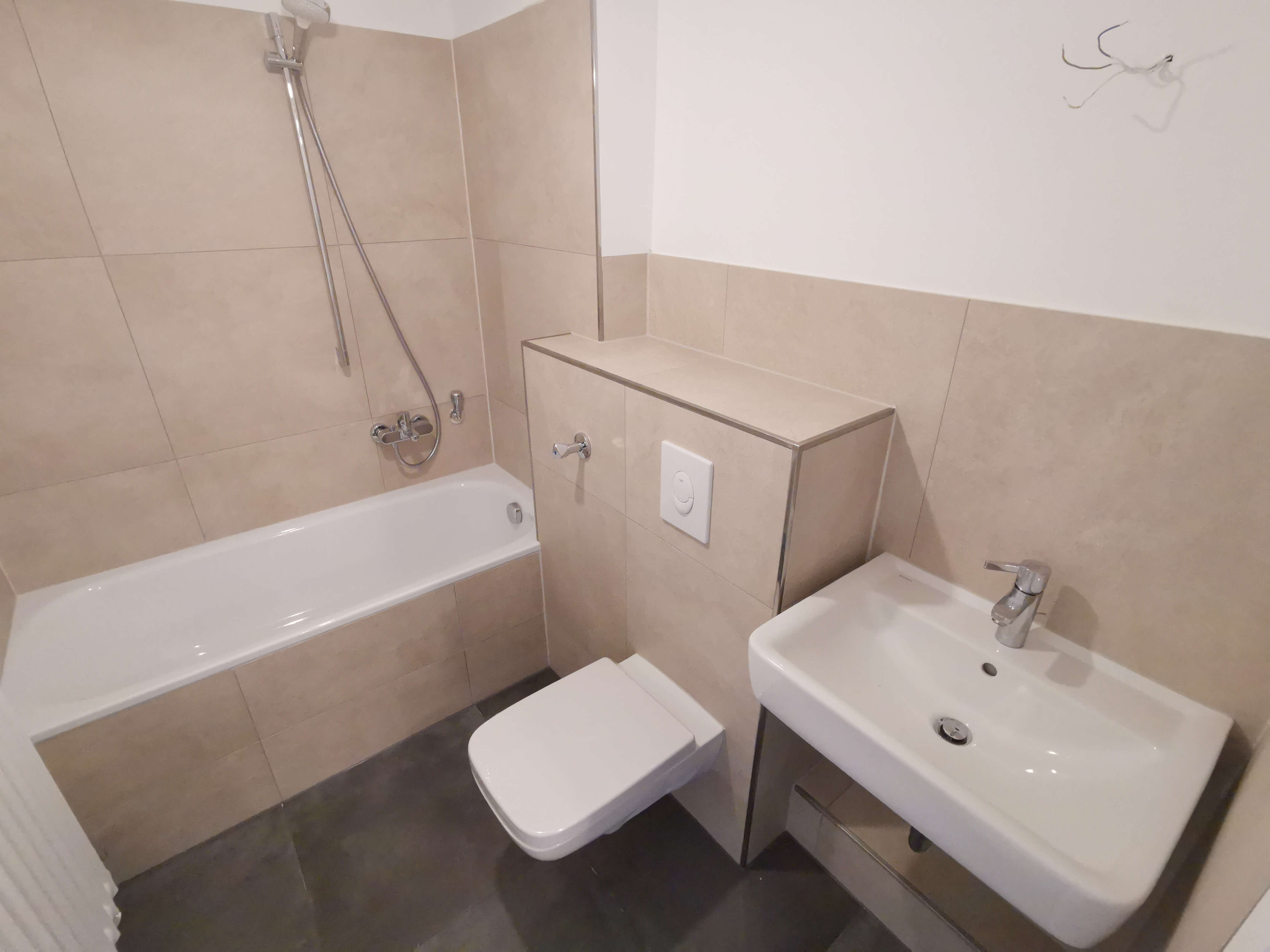 Modern saniertes Badezimmer mit Wanne und neuen Fliesen